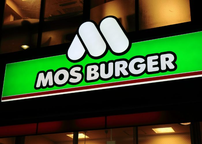The sign of Mos Burger, with the M logo and MOS BURGER set against a sign of bright green.